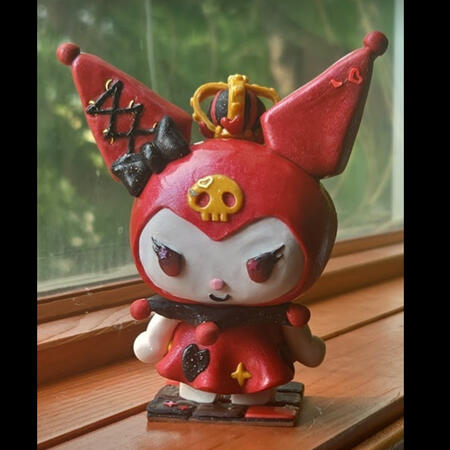 Kuromi Red and black Kuromi polymer clay figure with a gold crown, lace ear with a black bow beneath it. She is atop a checkerboard base.